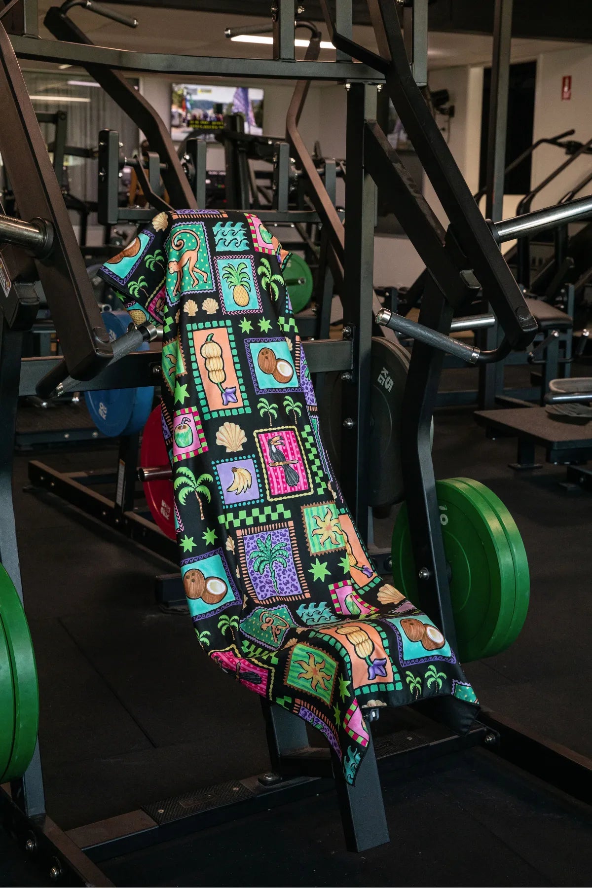 Black Tropics hooded gym towel by Nakari Studio, 140x60cm with zip pocket in hood, stays on gym bench, quick-dry and odour resistant by Cheeky Winx Australia.