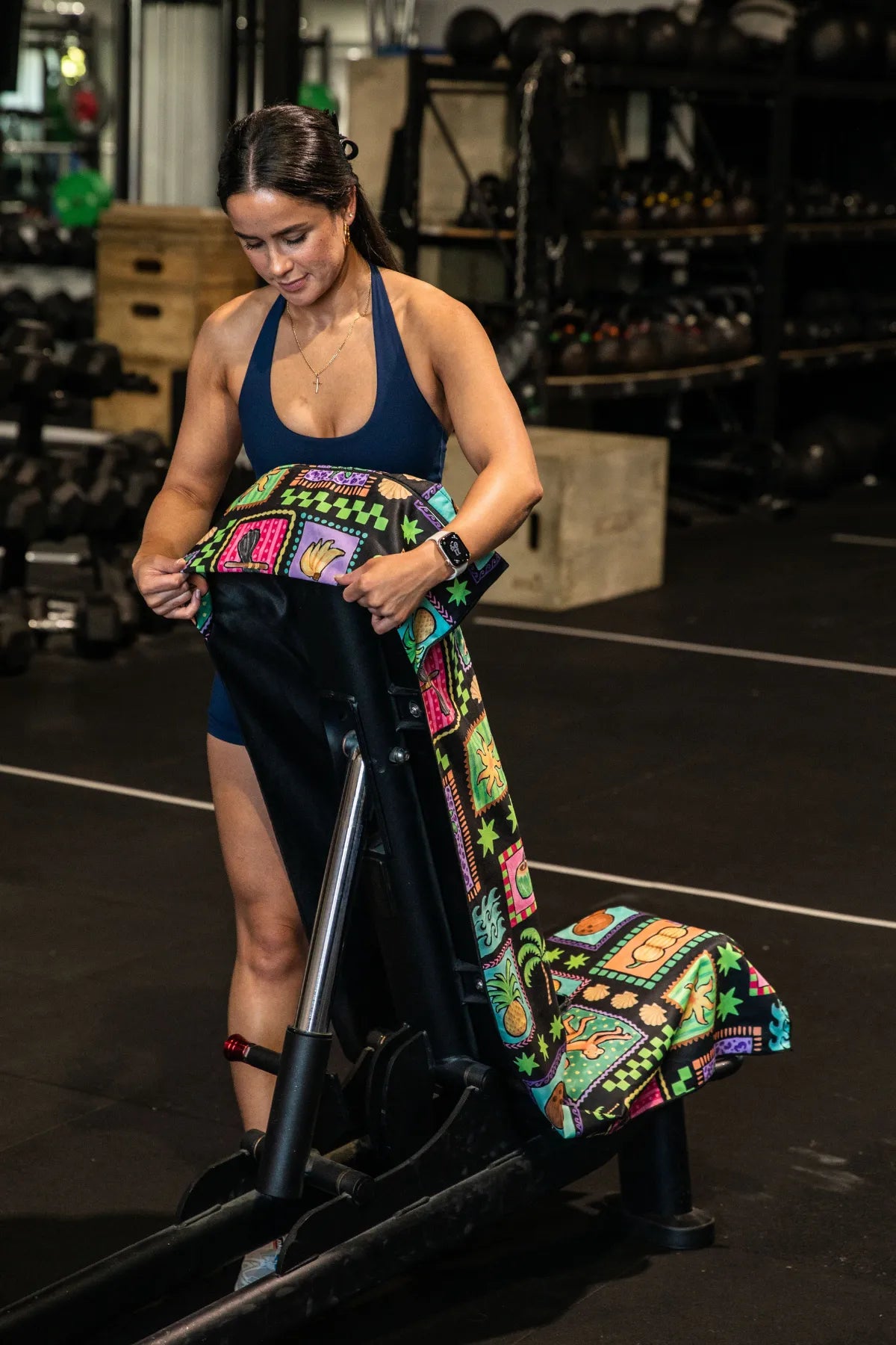 Black Tropics hooded gym towel by Nakari Studio, 140x60cm with zip pocket in hood, stays on gym bench, quick-dry and odour resistant by Cheeky Winx Australia.