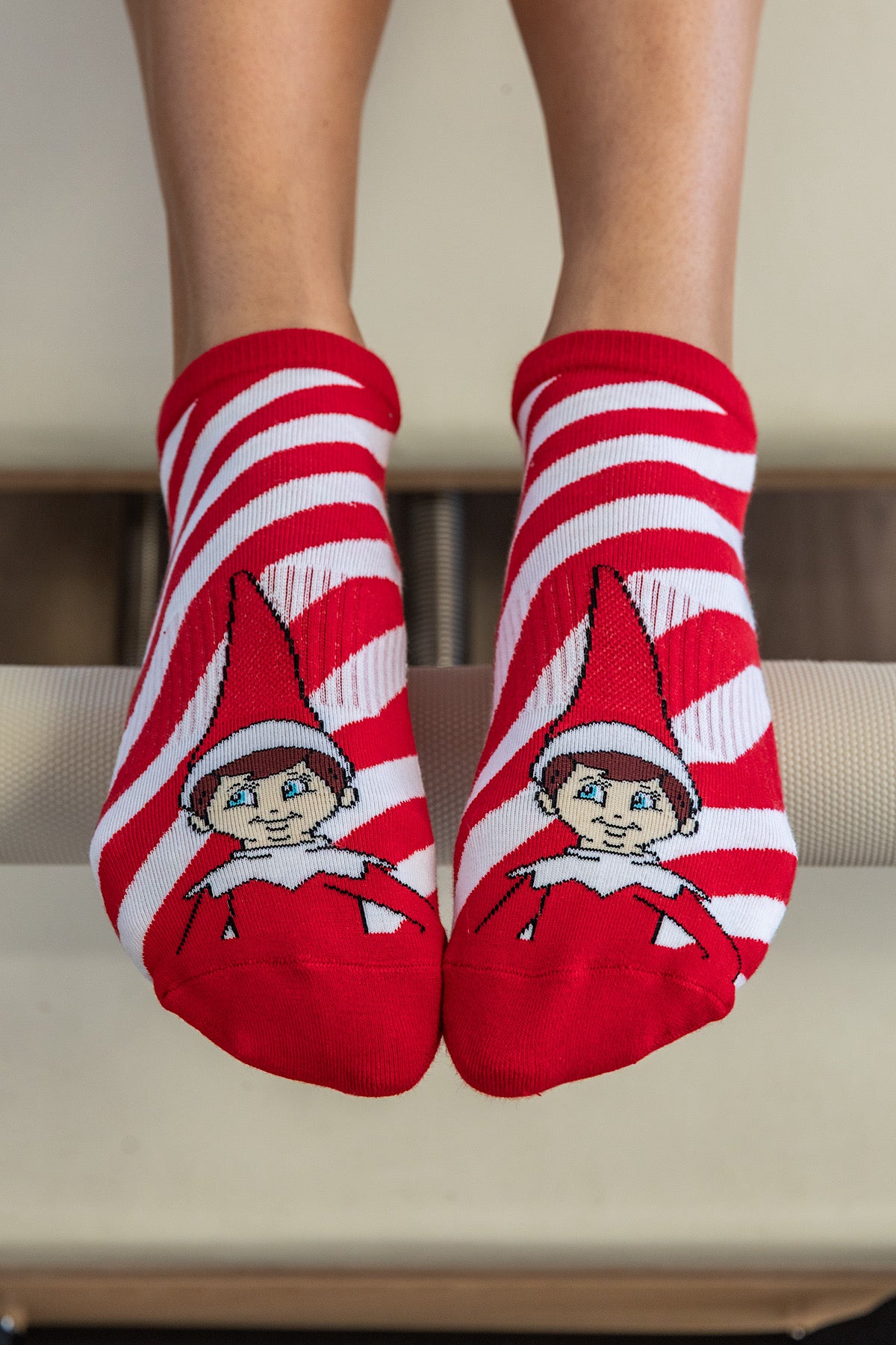 Red and white striped grip socks with the elf on the shelf designs for Christmas worn in pilates 